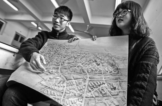 昨天上午，在努努影院
，手绘图的作者郭龙(左)和何菡丹(右)在展示他们的创作手稿。 记者 姚卡/摄